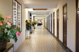 a corridor of a building with flowers and plants at Van der Valk Hotel Mechelen in Mechelen