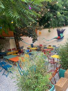 a patio with tables and chairs and a bird painted on the wall at YASI Hostel in Lyon