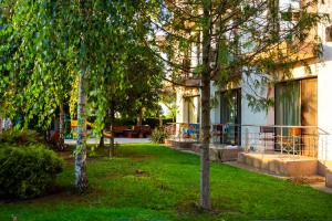 un patio con árboles frente a una casa en Vila La Mer, en Eforie Nord