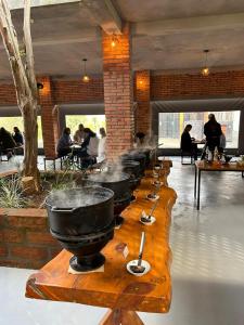 Pousada e Cervejaria Stein Haus في بيكادا كافيه: صف من الطاسات على طاولة خشبية في مطعم