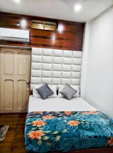 a small bedroom with a bed with a floral blanket at Hotel Florence in Siliguri