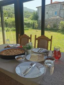 einen Tisch mit einem Tischtuch mit Essen drauf in der Unterkunft GOPO Guesthouse Elshani in Ohrid