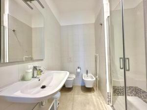 a white bathroom with a sink and a toilet at Le 4 Stagioni rooms in Francavilla al Mare