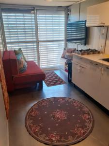 cocina con silla roja y alfombra en Luxury family caravan truck in the Golan Heights, en Bruchim Qela' Alon