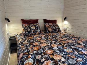 1 cama con edredón y almohadas en una habitación en Bed & Bike Resort Trzęsacz, en Trzęsacz