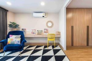 a living room with a blue chair and a yellow stool at Skyline view, Great location, Spacious apartment, in Bangkok