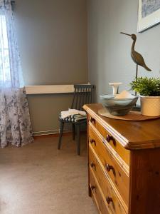 ein Zimmer mit einer Kommode mit einem Vogel darüber in der Unterkunft Hälsokällans Bed and Breakfast in Kyrkhult