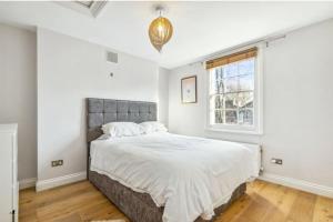 a bedroom with a large bed and a window at Stylish 2 FLOOR 2BED house 1 MIN walk to Camden station! FREE PARKING! in London