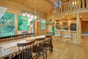 una sala da pranzo e una cucina in una baita di tronchi di Alexandria Cabin with Patio, Grill and Deck 