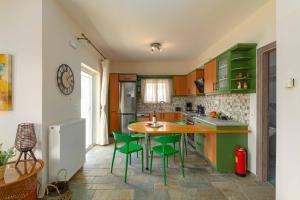a kitchen with green cabinets and a table and chairs at Villa Melenia 2 in Agia Pelagia +25 photos