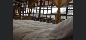un grande letto bianco in una stanza con finestre di Balcón de Qenqo a Cuzco