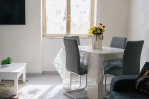 een witte tafel met stoelen en een vaas met bloemen erop bij La dimora delle zite in Napels