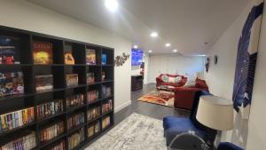 Alpine的住宿－Basement Getaway，客厅设有书架,书架上装满了dvd