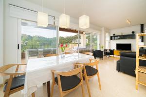 a dining room and living room with a white table and chairs at Casa Pianti villa in Altea Hills in Altea