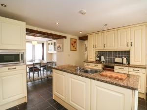 a kitchen with white cabinets and a sink at Toberlonagh 