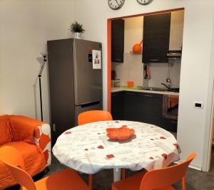 cocina con mesa, sillas y nevera en Tre Continenti - Appartamento con parcheggio privato, en Ronchi dei Legionari