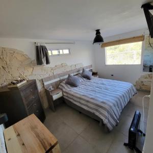a bedroom with a bed and a stone wall at La Colina - Potrero de los Funes in Potrero de los Funes