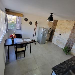 a kitchen with a table and a refrigerator at La Colina - Potrero de los Funes in Potrero de los Funes