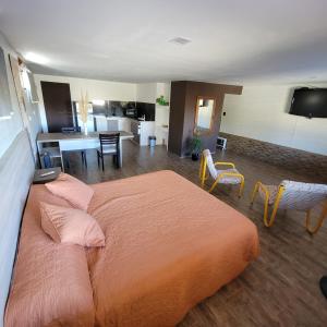 a bedroom with a large bed and a living room at La Colina - Potrero de los Funes in Potrero de los Funes