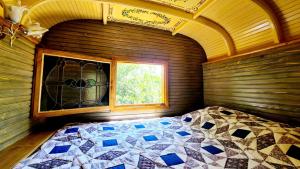 een slaapkamer met een bed in een kamer met een raam bij La Roulotte du Coustal, Cajarc, Lot in Cajarc