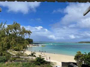 a beach with people and boats in the water at Villa de la Playa in Blue Bay