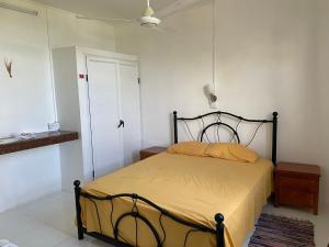 een slaapkamer met een bed met een zwart frame en een raam bij Villa de la Playa in Blue Bay