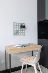 een houten bureau met een witte stoel en een tafel bij Trendy Studio Masarska Krakow Kazimierz by Renters Prestige in Krakau