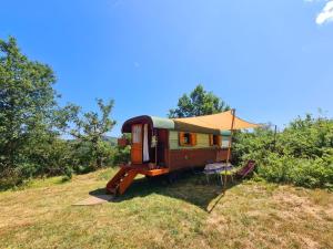 a tiny house sitting on top of a field at La Roulotte du Coustal, Cajarc, Lot in Cajarc