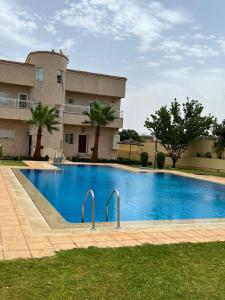 a large blue swimming pool in front of a building at Stunning 3-Bed Villa in Fes near fes sais airport in Fès