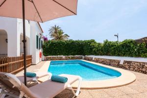 een zwembad met 2 stoelen en een parasol bij Villa Calan Brut 51 in Cala en Blanes