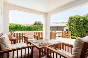 een patio met een tafel en stoelen en een parasol bij Villa Calan Brut 51 in Cala en Blanes