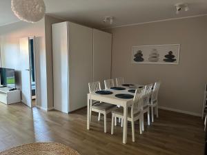 a dining room with a white table and chairs at Amko Style Apartamenty Las Palmas Villa Pilece in Jastrzębia Góra