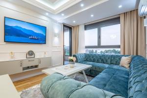 een woonkamer met een blauwe bank en een tv bij Lux Apartment Amore in Bar