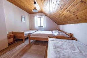 a room with four beds and a wooden ceiling at Apartmány v Müllerovom dome in Banská Štiavnica