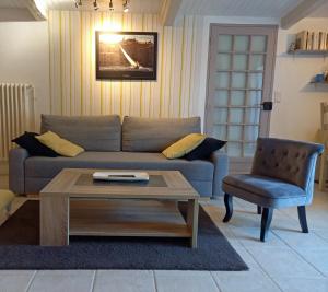 a living room with a couch and a table and a chair at T2 de charme 55 m² au calme avec terrasse ombragée 40m2 in Carnoules