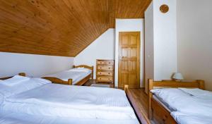 a bedroom with two beds and a wooden ceiling at Apartmány v Müllerovom dome in Banská Štiavnica