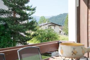 eine Tasse Kaffee auf einem Tisch auf einem Balkon in der Unterkunft Central flat for 6 persons Pianura Crapera Lenzerheide in Lenzerheide