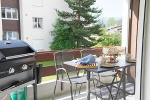 einen Tisch und Stühle auf einem Balkon mit Grill in der Unterkunft Central flat for 6 persons Pianura Crapera Lenzerheide in Lenzerheide
