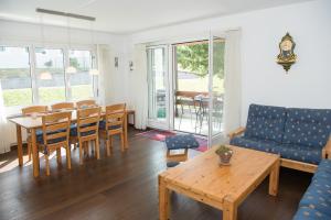 ein Wohnzimmer mit einem Tisch, Stühlen und einem Sofa in der Unterkunft Central flat for 6 persons Pianura Crapera Lenzerheide in Lenzerheide