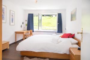 ein Schlafzimmer mit einem großen weißen Bett und einem Fenster in der Unterkunft Central flat for 6 persons Pianura Crapera Lenzerheide in Lenzerheide