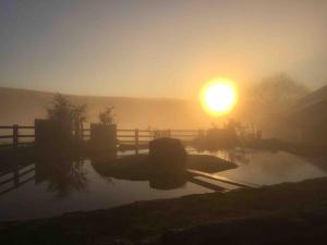 a misty sunrise with the sun in the background at Knoll Top Cottage in Todmorden