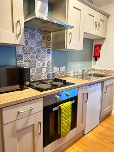a kitchen with white cabinets and a stove top oven at Bangor Central Apartments in Bangor