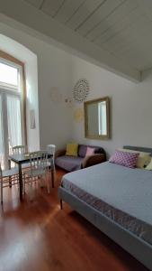 een slaapkamer met een bed, een tafel en een bank bij Mandala in Bari