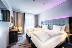 ein Hotelzimmer mit 2 Betten und einem Schreibtisch in der Unterkunft Premier Inn Wiesbaden City Centre in Wiesbaden