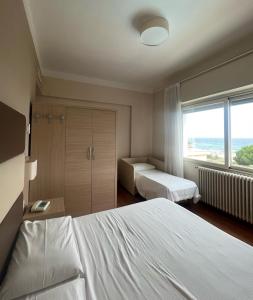 ein Hotelzimmer mit 2 Betten und einem Fenster in der Unterkunft Hotel Napoleon in Sanremo