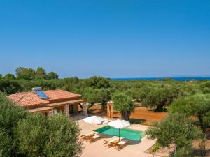 an external view of a villa with a swimming pool at Terra Oleana Cottages in Vasilikos