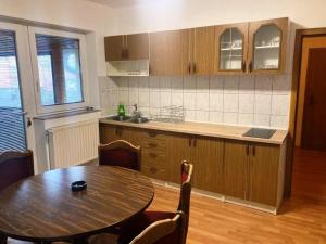 a kitchen with a wooden table and a table and chairs at Apartman Kraljica 1 in Kupres