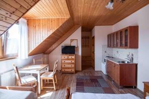 a kitchen with a wooden ceiling with a table and a desk at Apartmány v Müllerovom dome in Banská Štiavnica