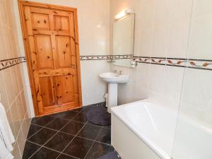 a bathroom with a sink and a tub and a toilet at 29 Church Field in Doonbeg