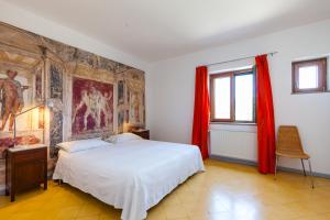 ein Schlafzimmer mit einem Bett und einem Gemälde an der Wand in der Unterkunft Natursteinvilla mit Meerblick , 2km über dem Meer-Cilentissimo in Santa Maria di Castellabate